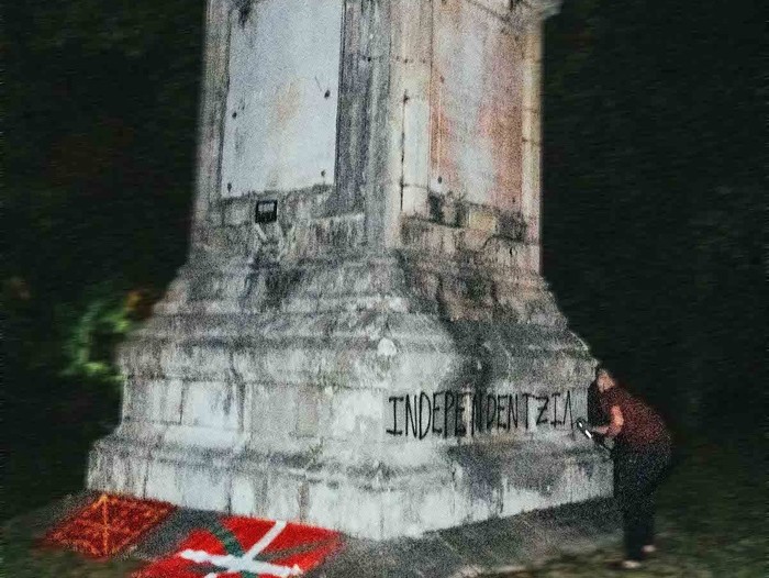 Momento de la acción de Ernai. Haciendo una pintada de Independentzia en el monumento ubicado en la isla